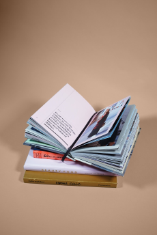 Ein Bild von einem Stapel Büchern, das oberste von Ihnen ist aufgeschlagen