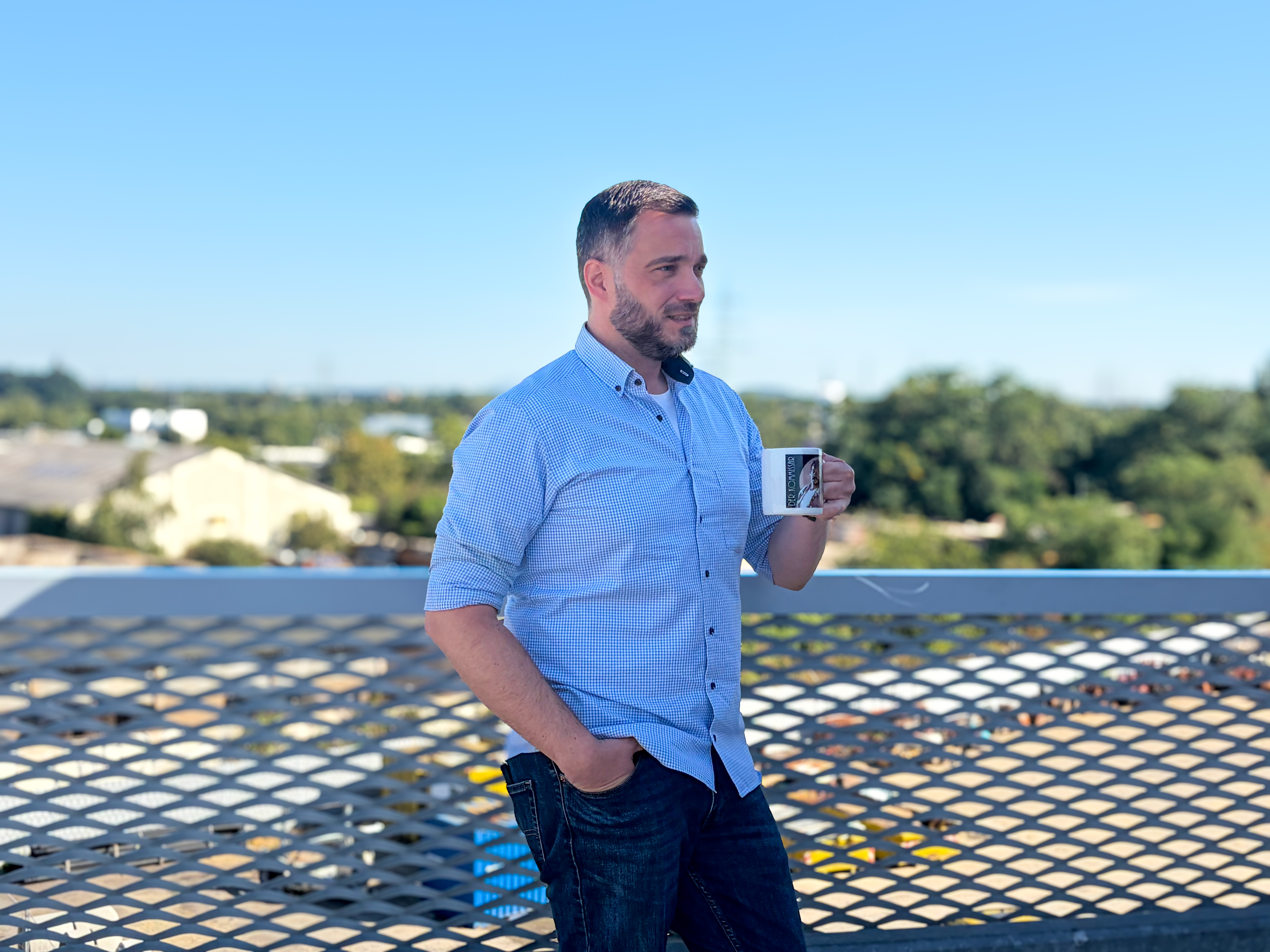 Porträt Frederik Stepprath mit Tasse in der Hand auf Parkdeck