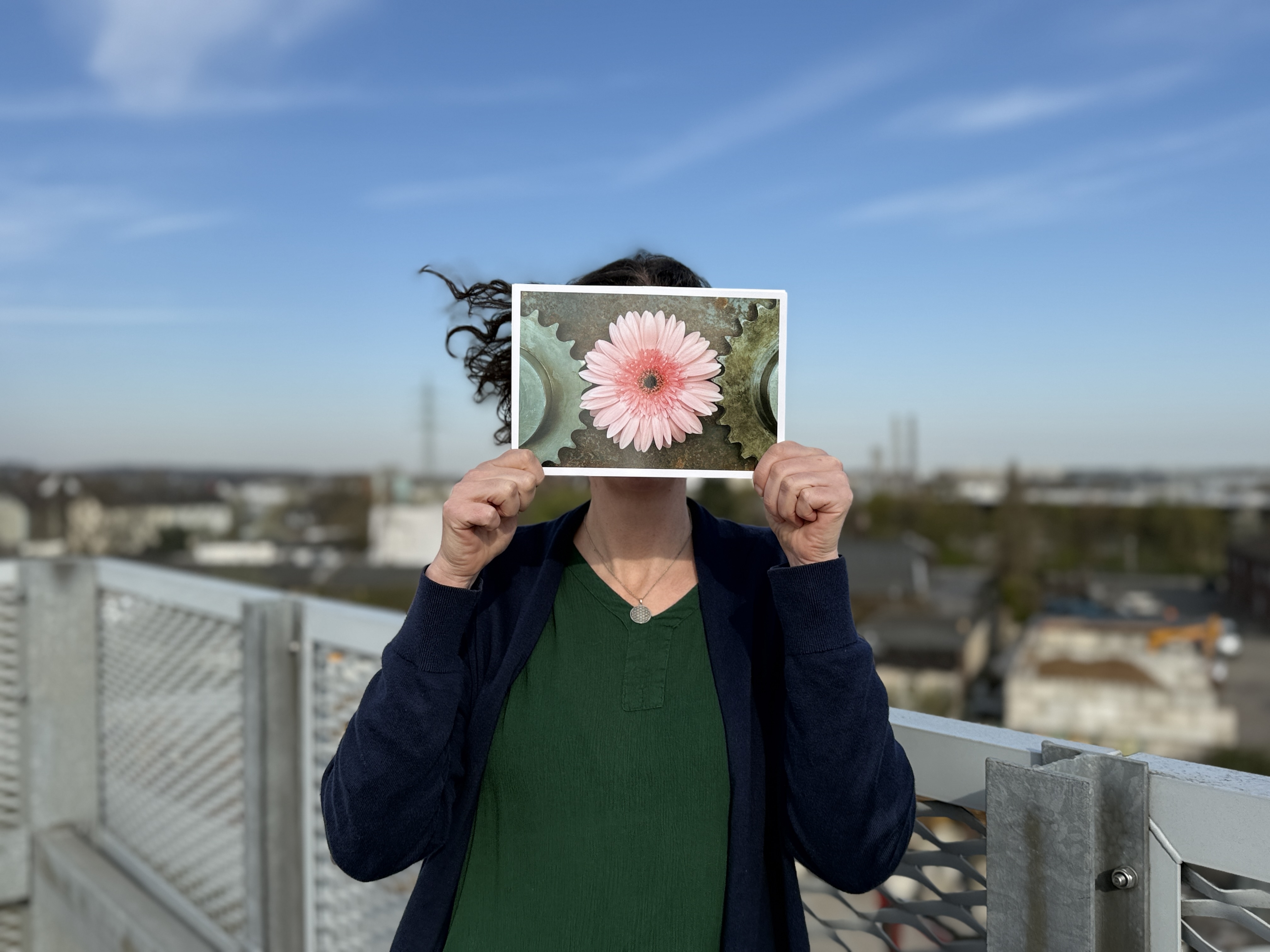 Katja Schanetzky steht auf dem Parkdeck und hält eine Karte mit einer Blume vors Gesicht