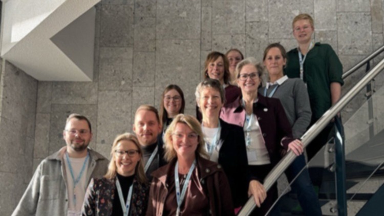 Männer und Frauen stehen aufgereiht auf einer Treppe