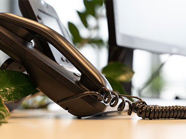 Schwarzes Bürotelefon auf Schreibtisch