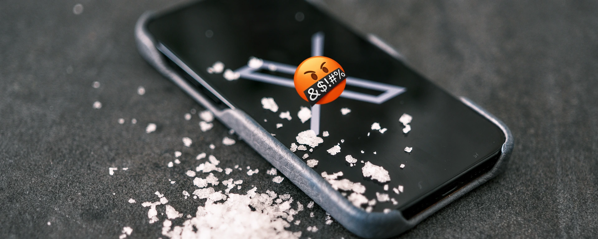 Handy, Salzkristalle und ein Emoji mit einem wütenden Gesichtsausdruck