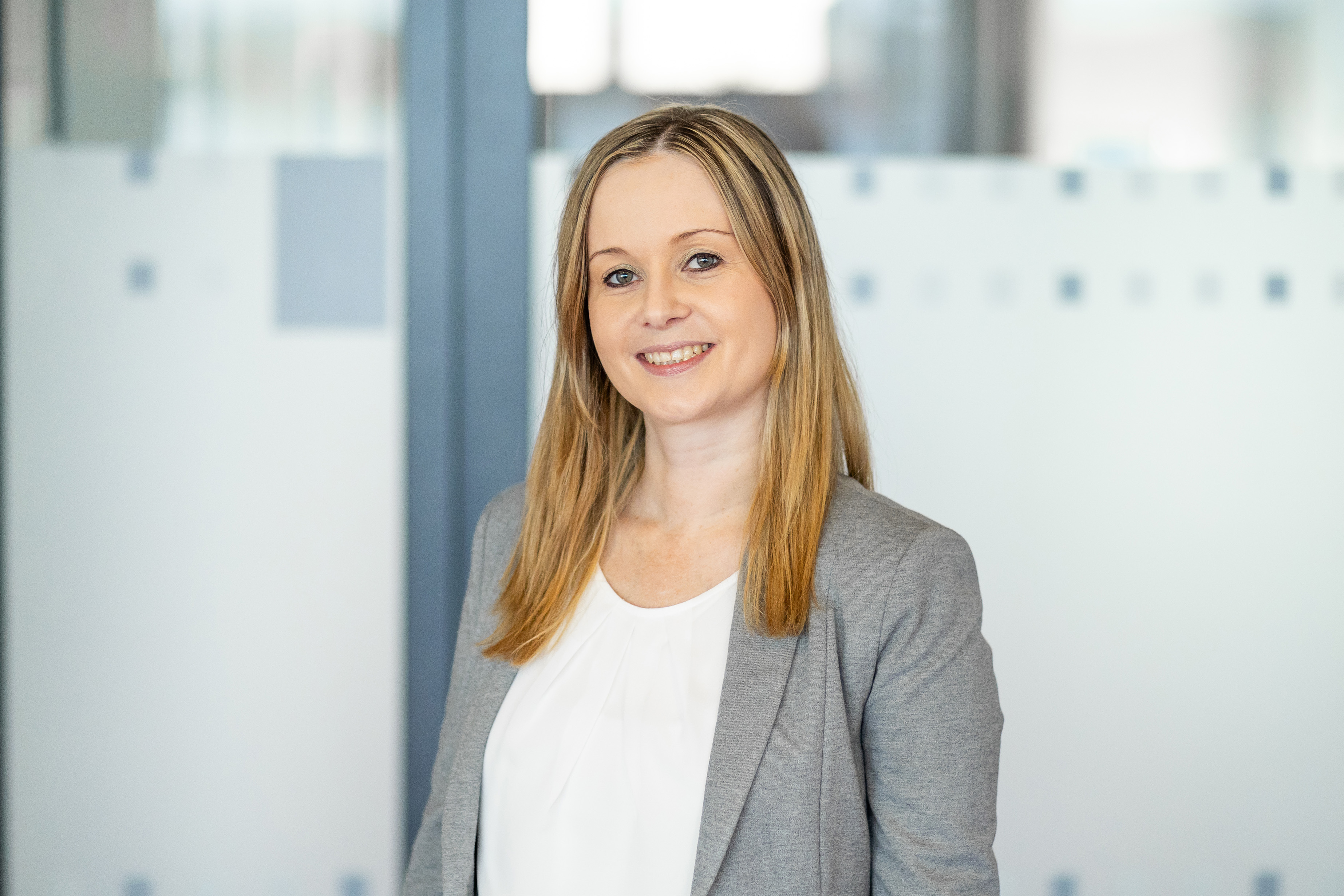 Julia Leibold im Porträt vor einer Glasfront