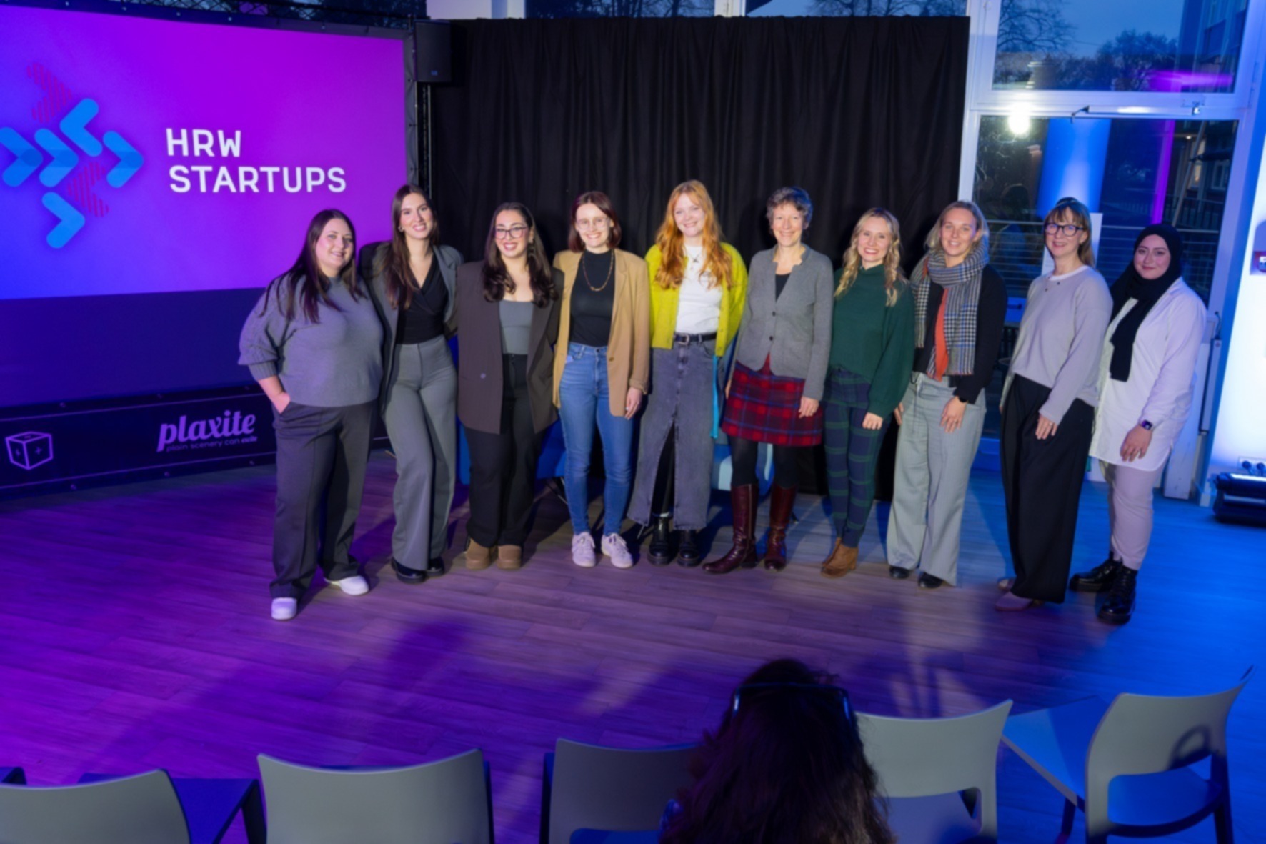 Zehn Frauen stehen nebeneinander auf einer Bühne