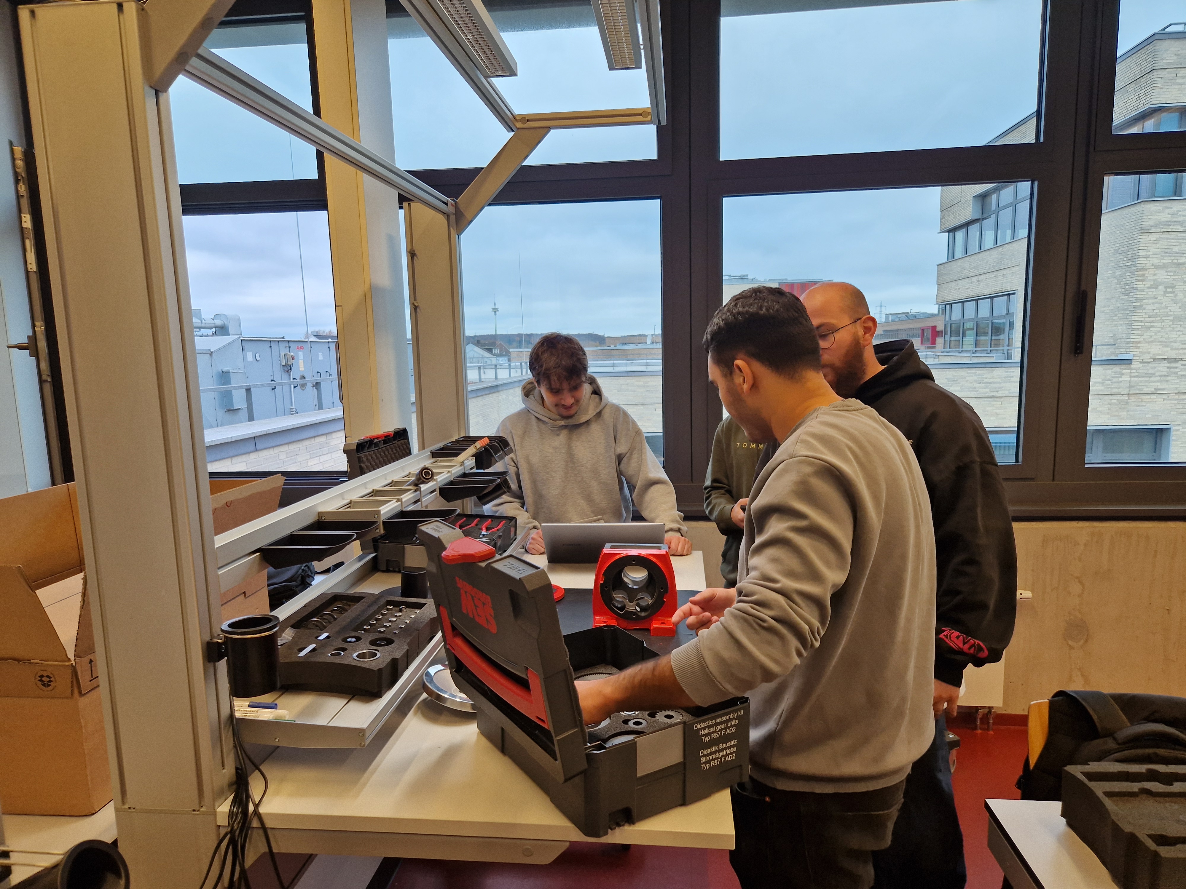 Studierende beugen sich über eine Versuchsanordnung.