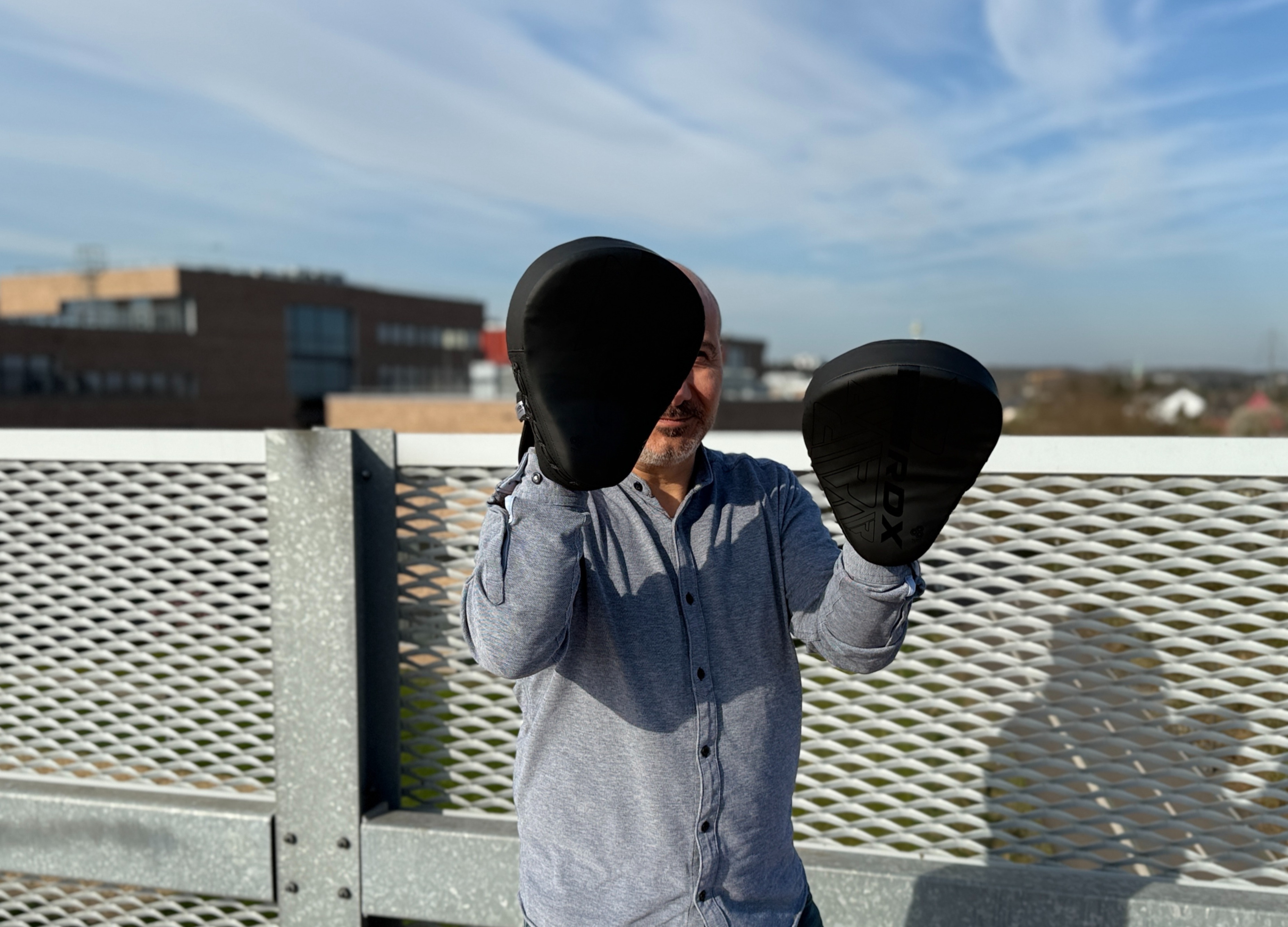 Özcan Tek steht auf dem Parkdeck mit Pratzen an den Händen