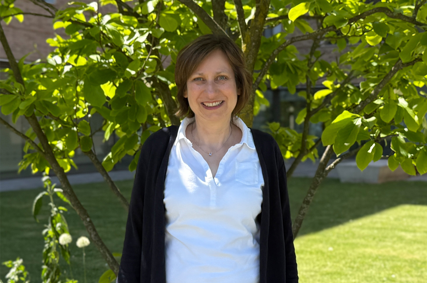 Porträt Christiane Hinrichs stehend vor einem Baum