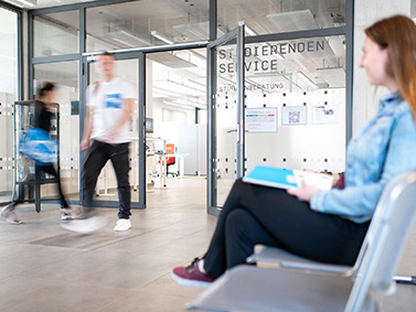 Studierende sitzt im Wartebereich des Studierenden Service Centers