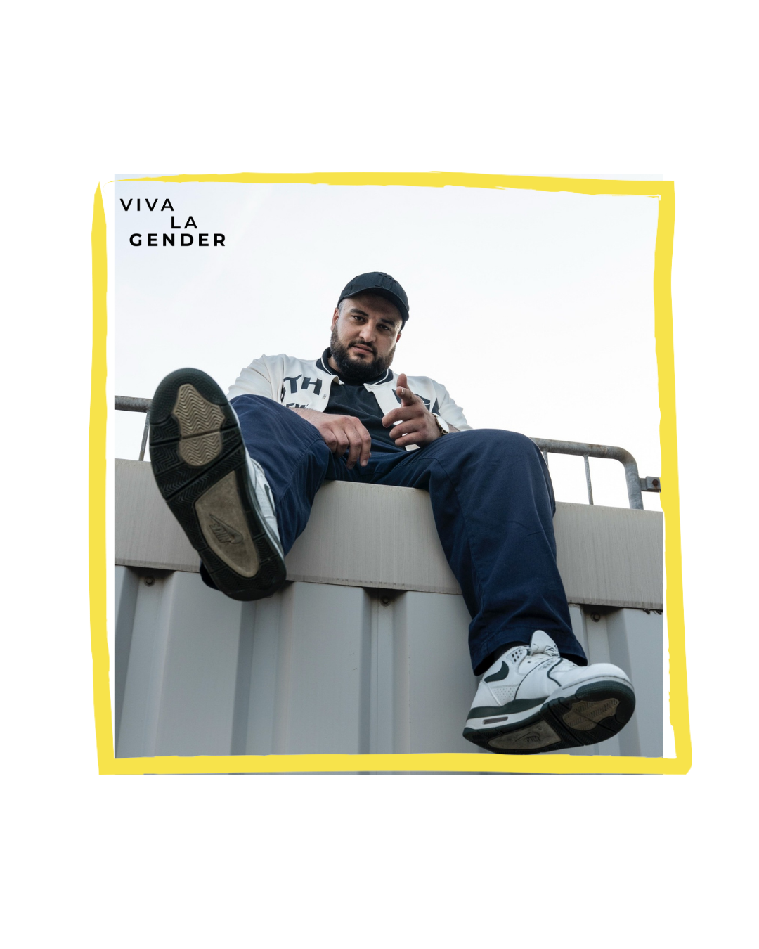 Untersicht: Mann mit Kappe sitzt auf Geländer, zeigt zur Kamera; Sneaker dominieren. Gelber Rahmen, Text 'Viva La Gender'.