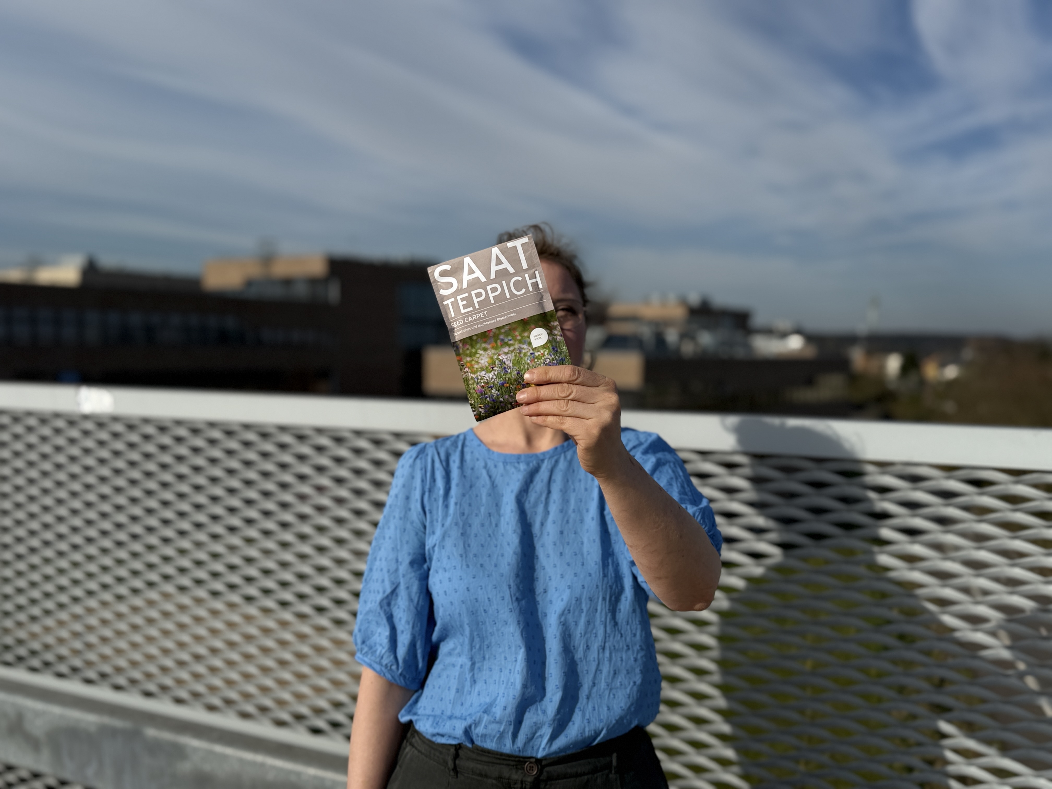 Esther Egener steht auf dem Parkdeck und hält eine Samentüte vor die Kamera