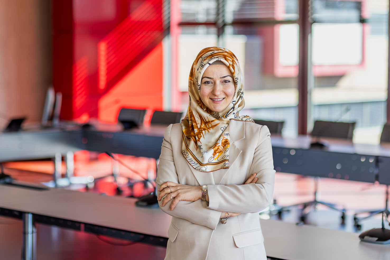 Ayse Dogangün grinst in die Kamera mit verschränkten Armen