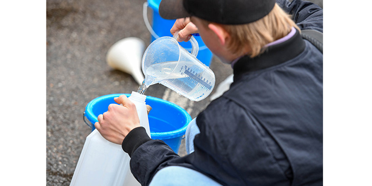 Ein Mann füllt Wasser in ein Kanister ab