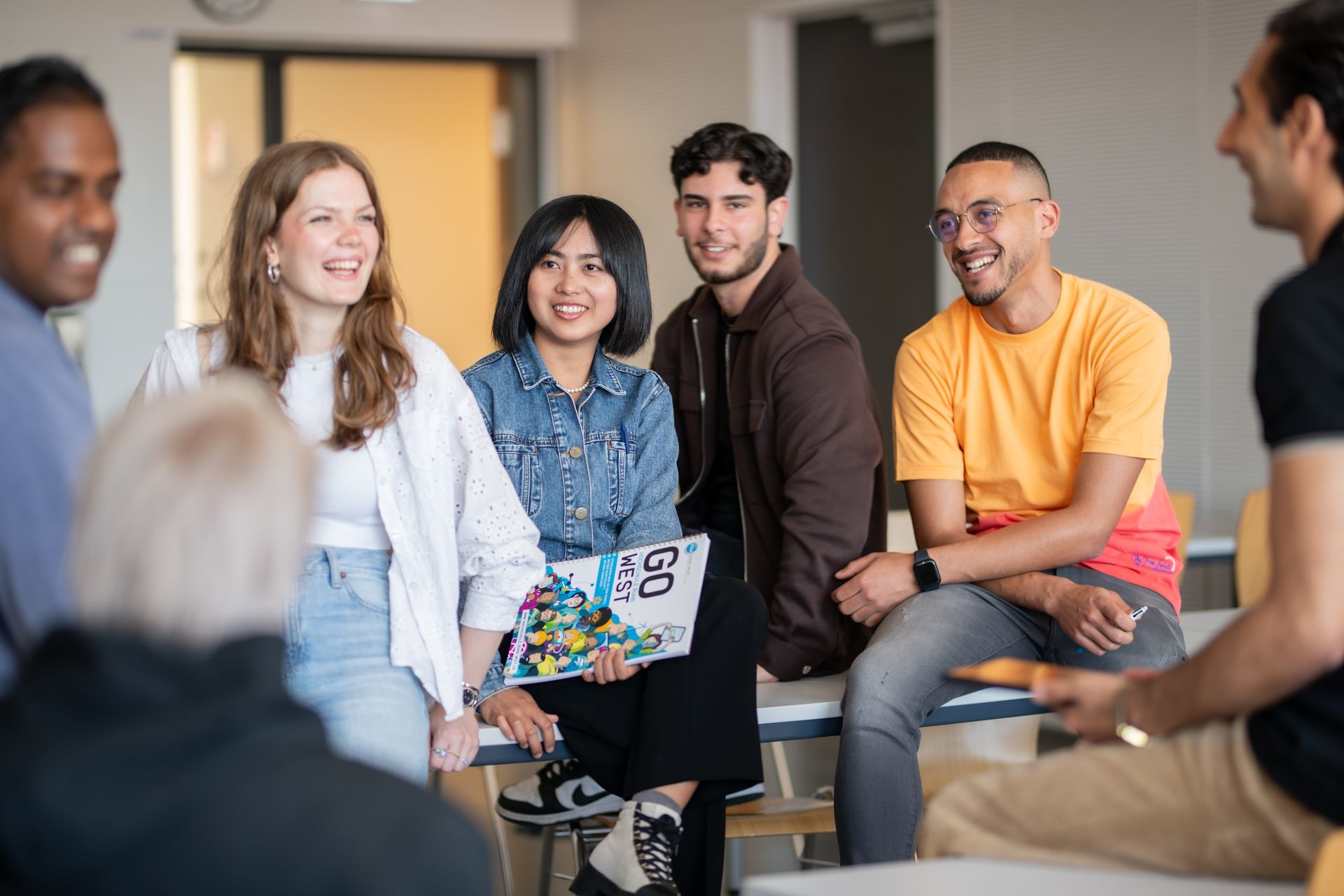 Studierende der Hochschule Ruhr West tauschen sich in entspannter Atmosphäre aus. Das Bild zeigt die Vielfalt, Offenheit und gelebte Gemeinschaft an der HRW – zentral für ein modernes, interkulturelles Studium.