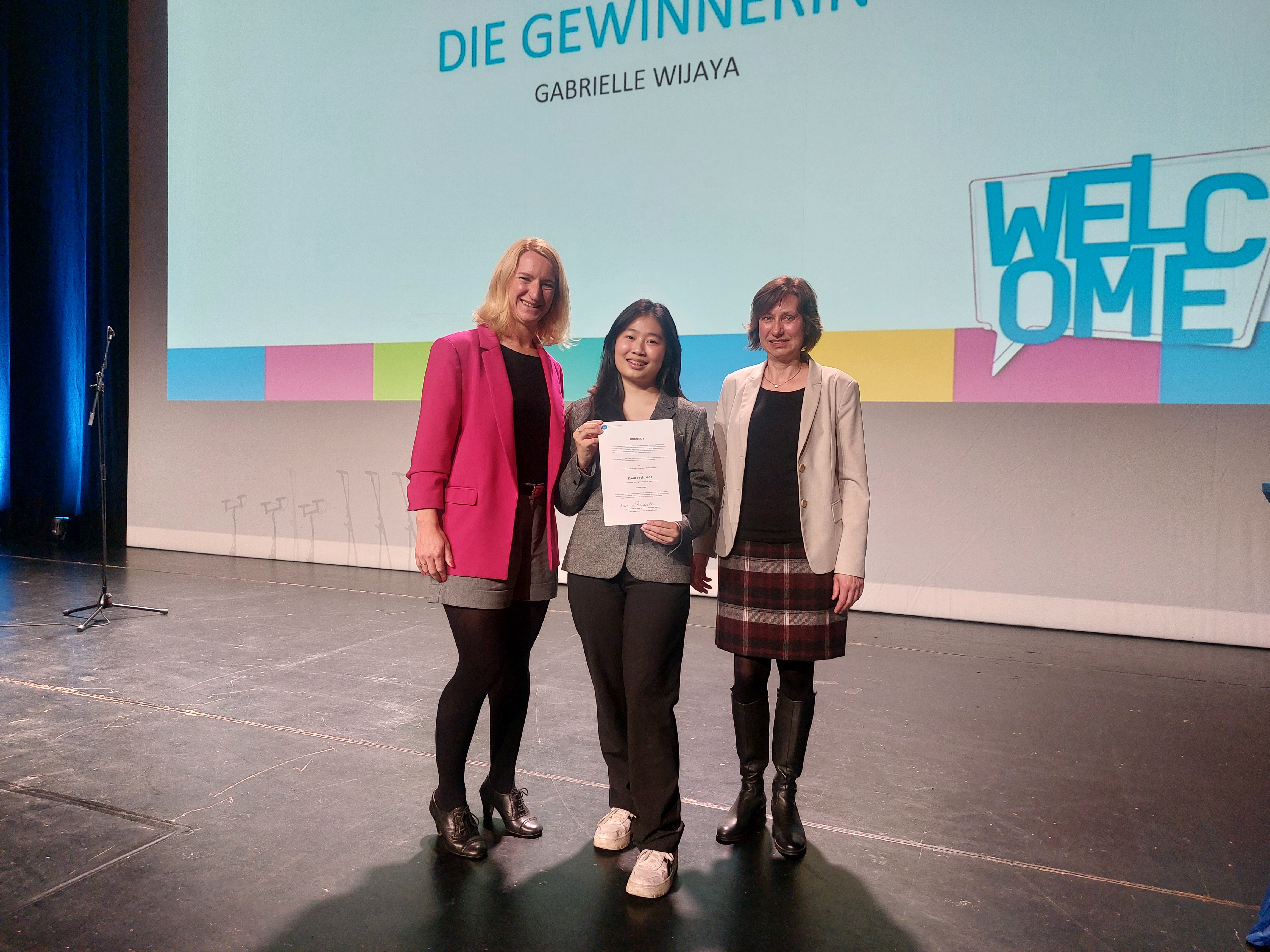 Drei Frauen (2 Professorinnen und eine Studentin) auf einer Bühne