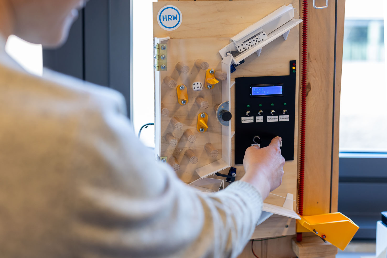 selbstgebaute Würfelmaschine frontal mit Finger auf Taster