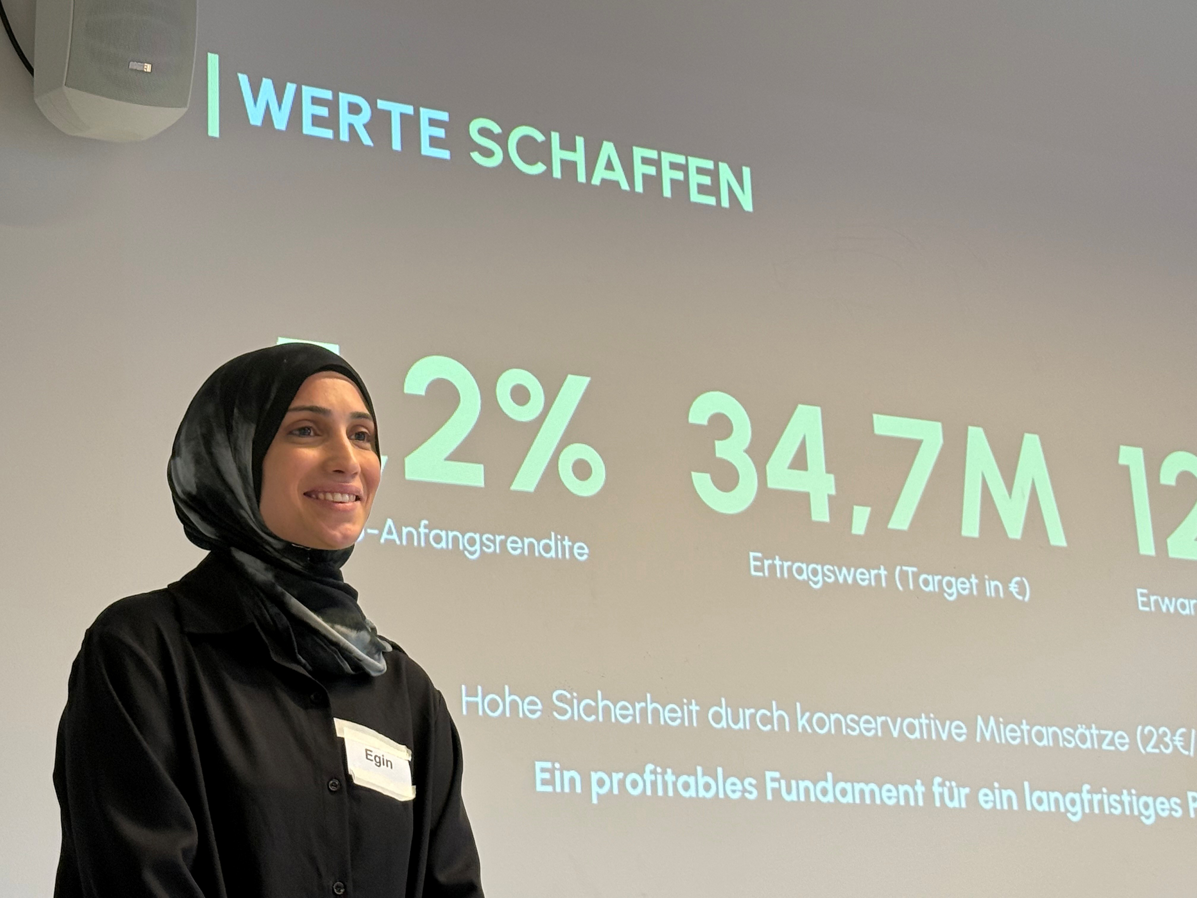 Studentin lächelt vor einer Präsentation.