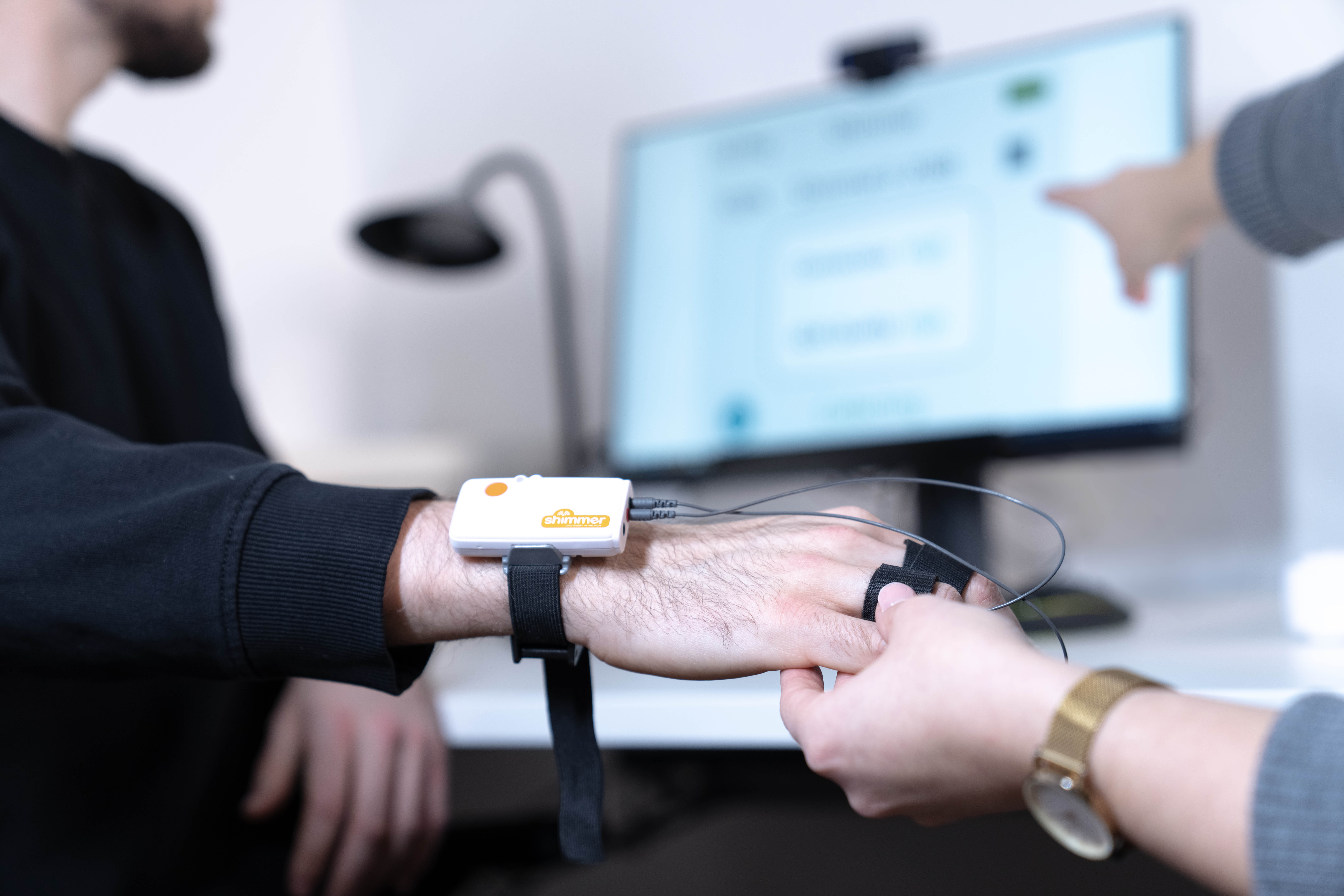 Das Foto zeigt eine Hand eines Probanden mit Equipment für das Eyetracking
