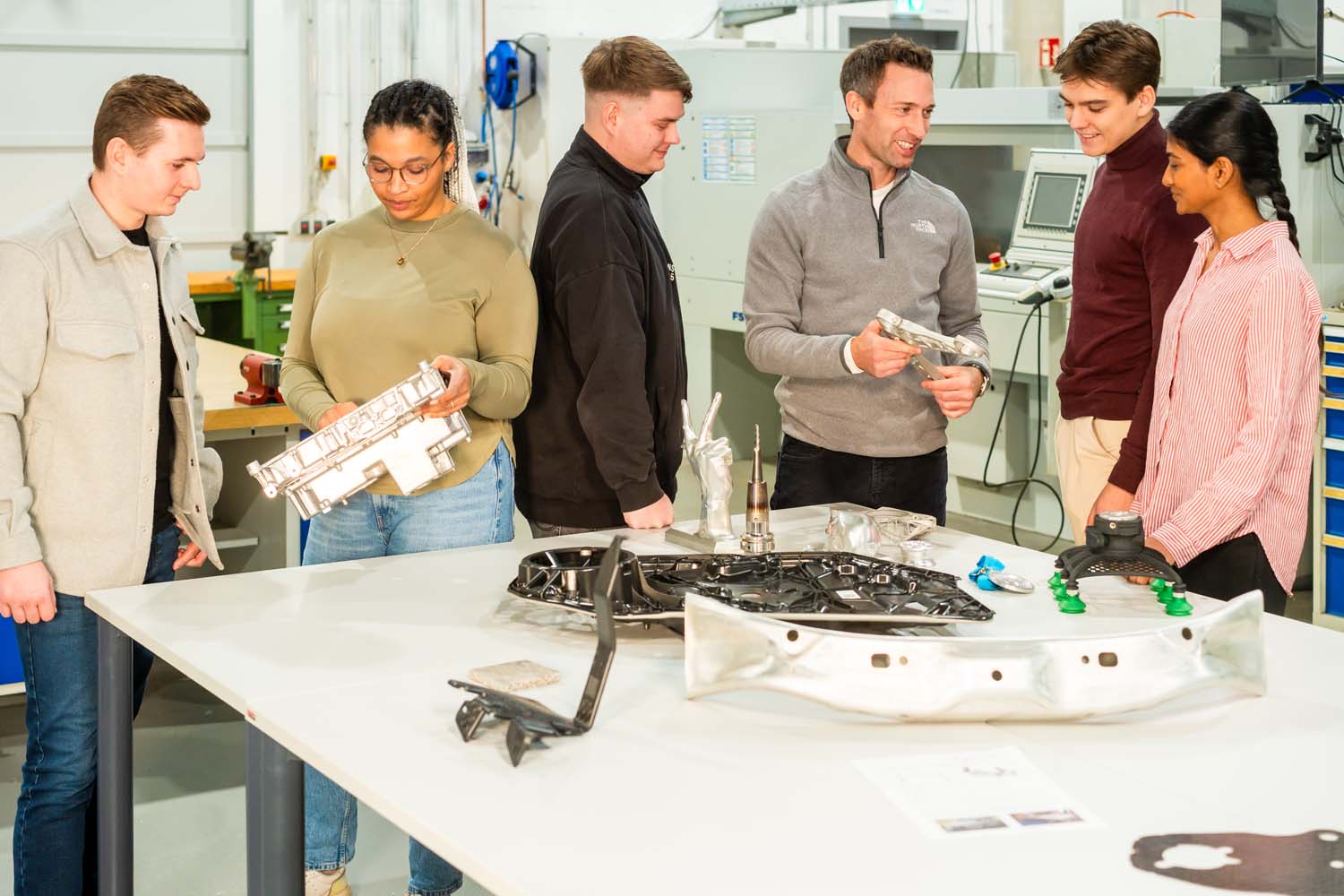 Dozent in Gespräch mit Studierenden in Kleingruppen.jpg