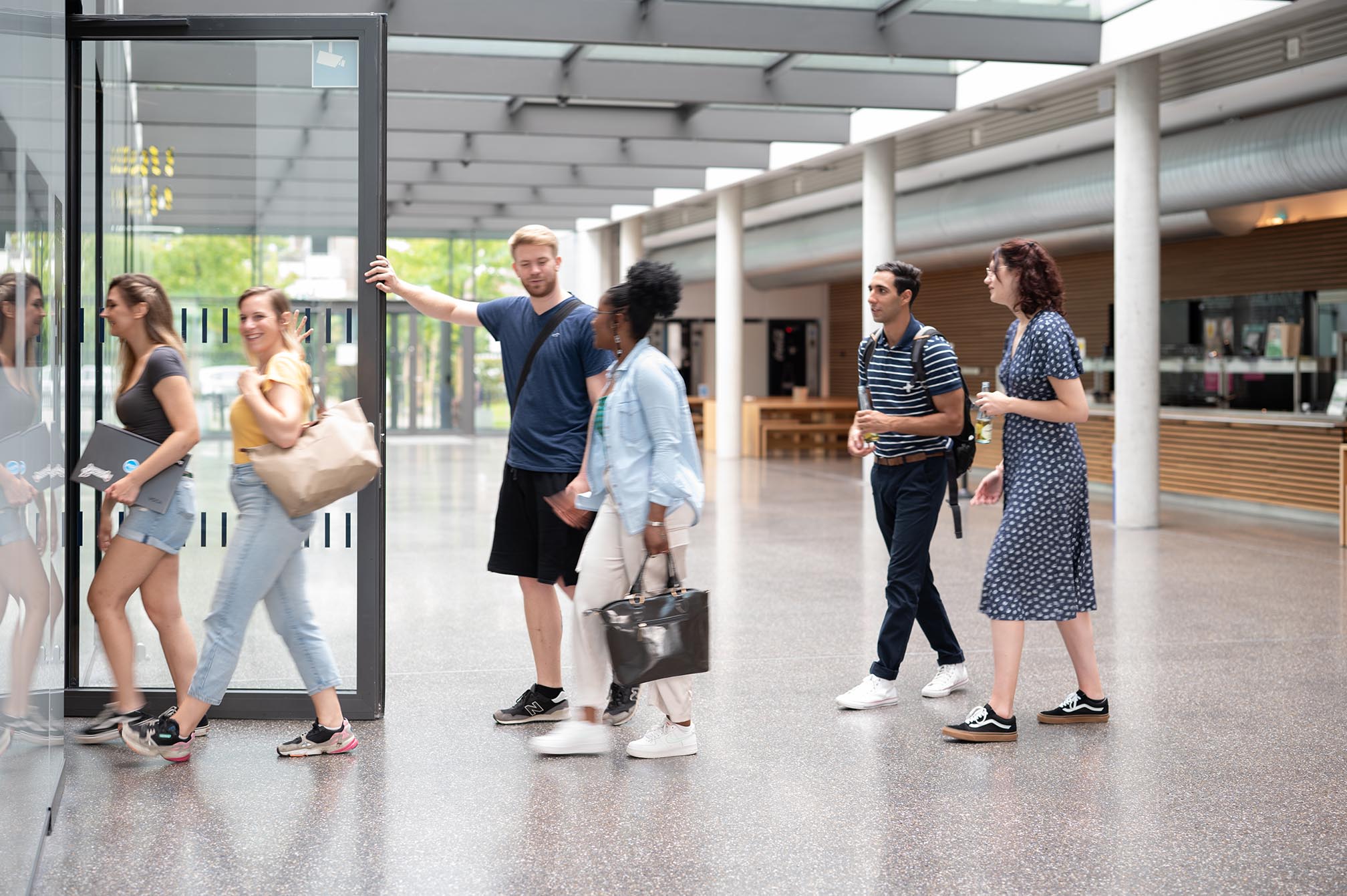 Eine Gruppe von Studierenden geht vom Cafeteria im Campus Bottrop in ein Hörsaal.