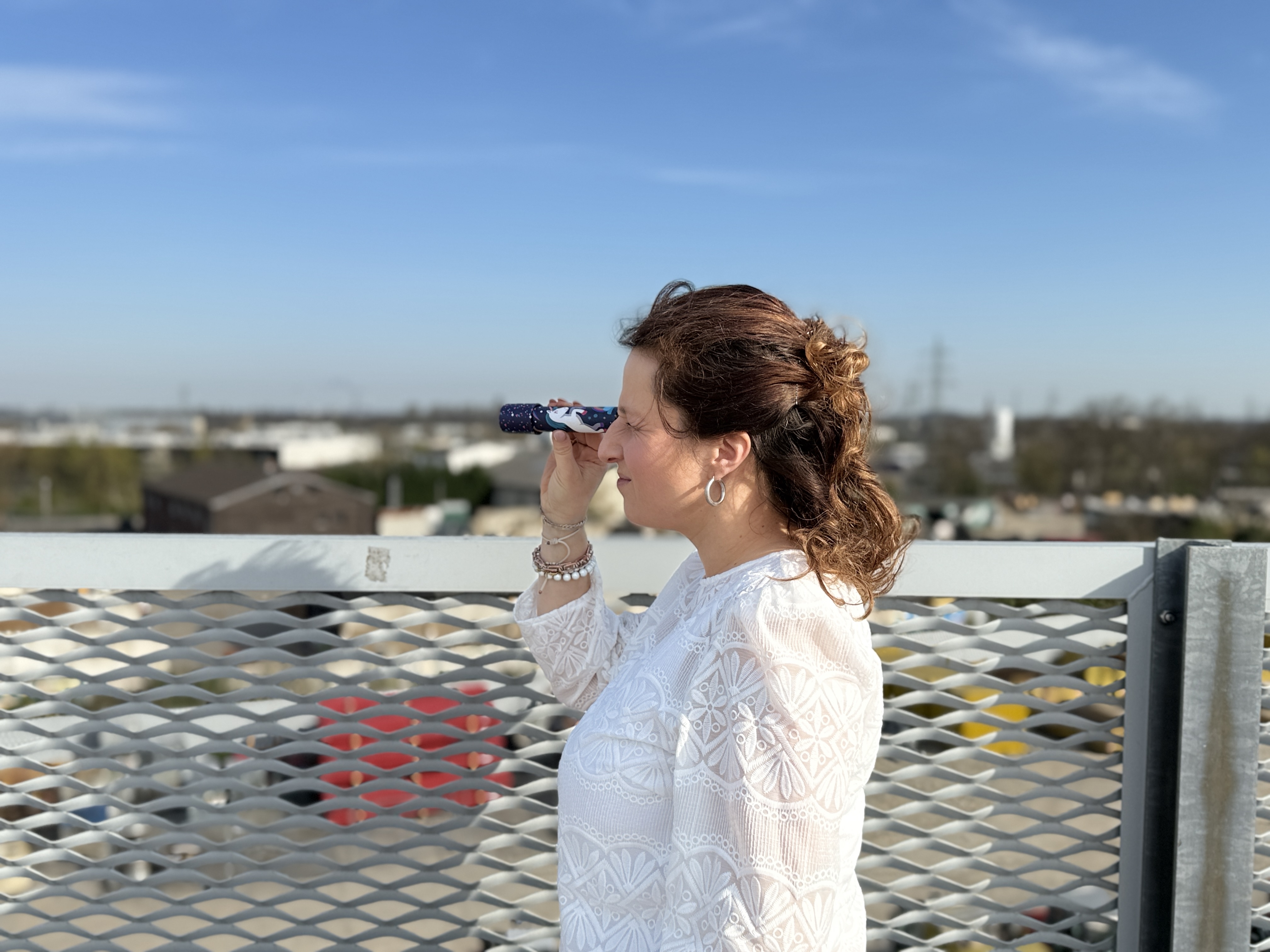 Lena Kamps-Engel steht auf dem Parkdeck und schaut durch ein Kaleidoskop