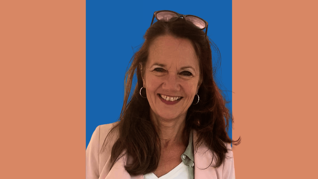 Porträt einer lächelnden Frau mit langen braunen Haaren, rosa Blazer und weißer Bluse vor einem grafischen Hintergrund in Blau und Terrakotta. Oben steht das Logo „LaKof“, unten der Schriftzug „Wenn beim Geld die Liebe aufhört – Finanzielle Gewalt gegen Frauen“, daneben das Logo der Hochschule Ruhr West mit dem Hinweis „Zentrale Gleichstellung“.