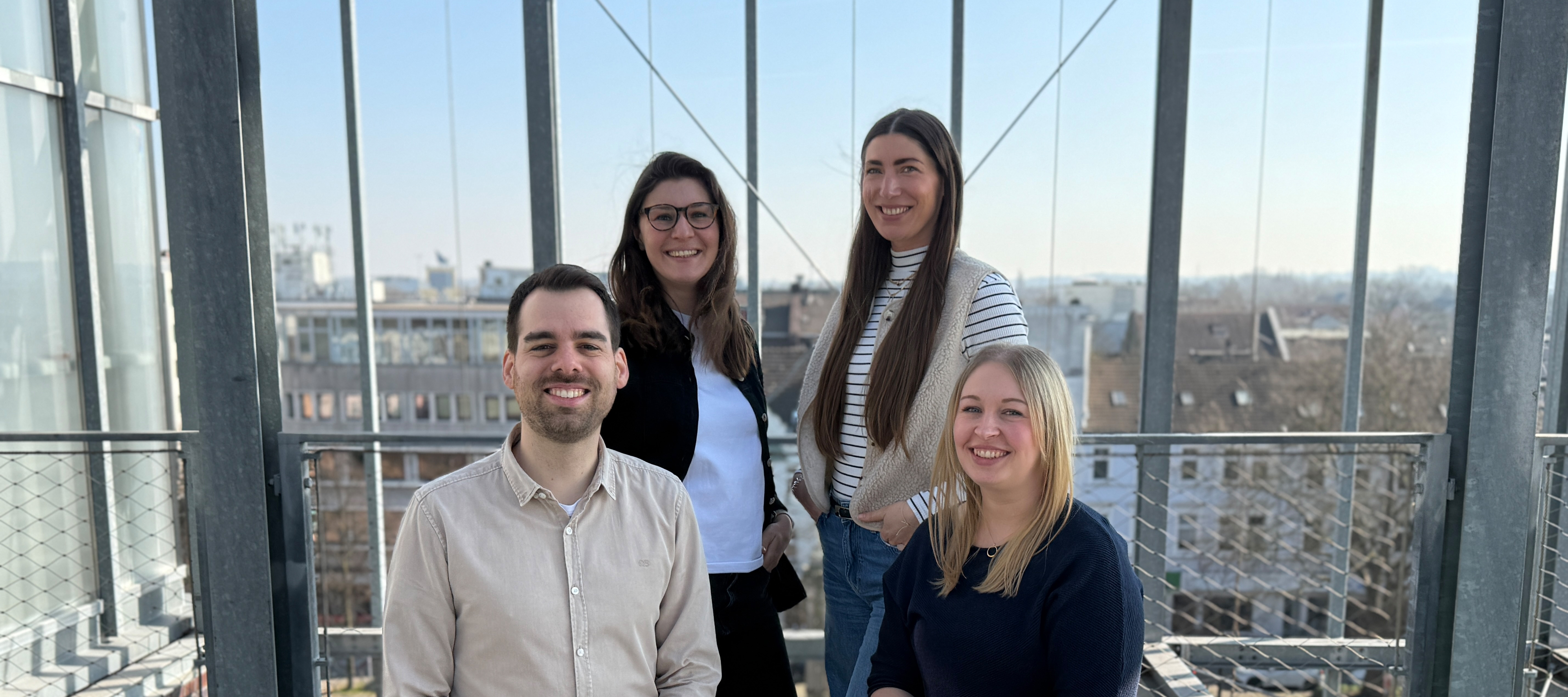 Vier Personen auf einem Gruppenbild mit Ausblick auf die Oberhausener Innenstadt im Hintergrund