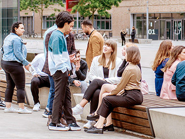 Gruppe internationaler Studierende unterhalten sich draußen auf dem Campus in Mülheim