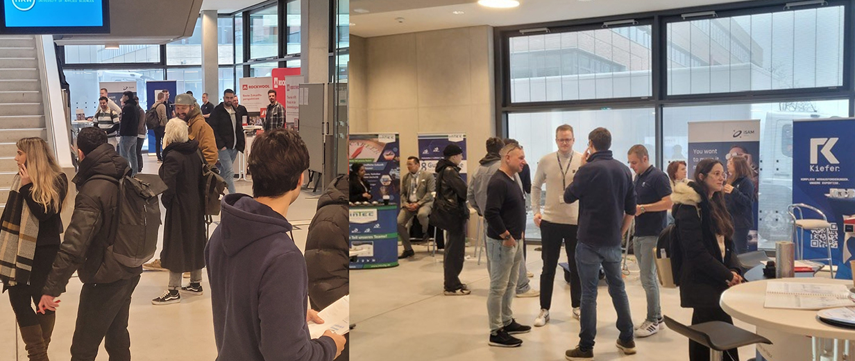 Frauen und Männer stehen im Foyer eines Gebäudes der Hochschule Ruhr West und unterhalten sich miteinander.