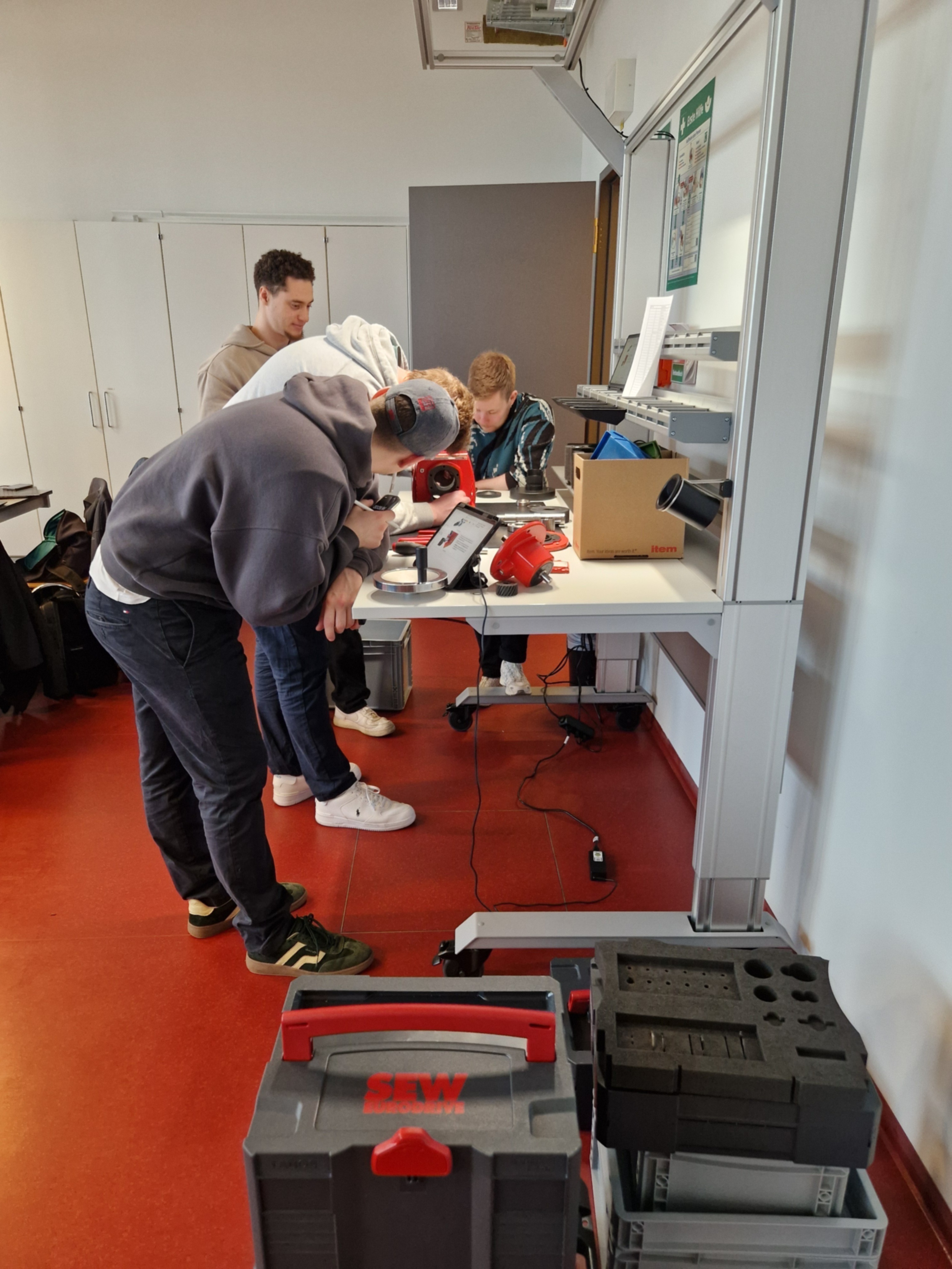 Studierende beugen sich über eine Versuchsanordnung.