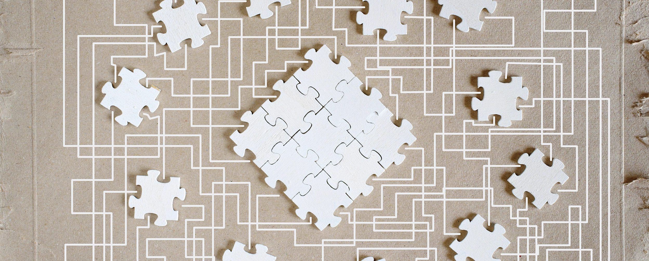 Weiße Puzzle-Teile liegen auf einem beigen Hintergrund mit überlagerten, verschlungenen Linien; in der Mitte ist ein fast vollständiges Puzzle zusammengesetzt.
