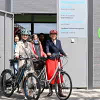 Mehrere Frauen mit Fahrrad vor dem Fahrrad-Parkhaus.